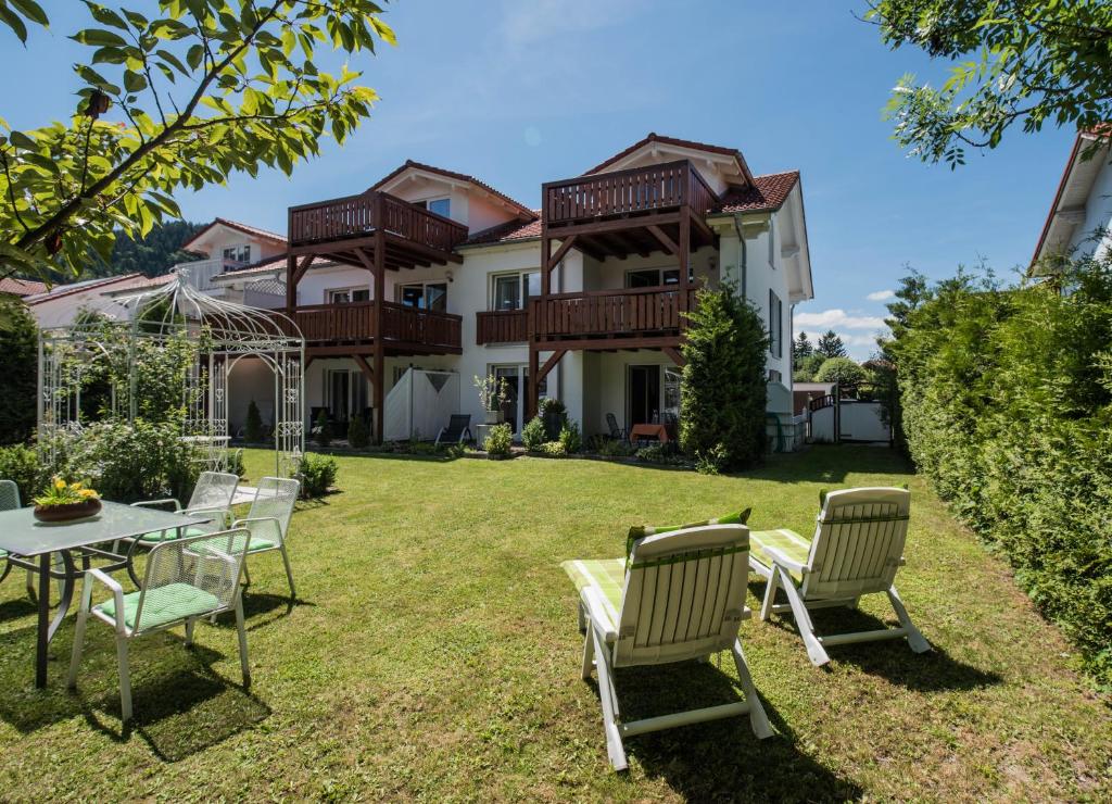 ein Haus mit einem Tisch und Stühlen im Hof in der Unterkunft Ferienwohnungen Rexha in Schwangau