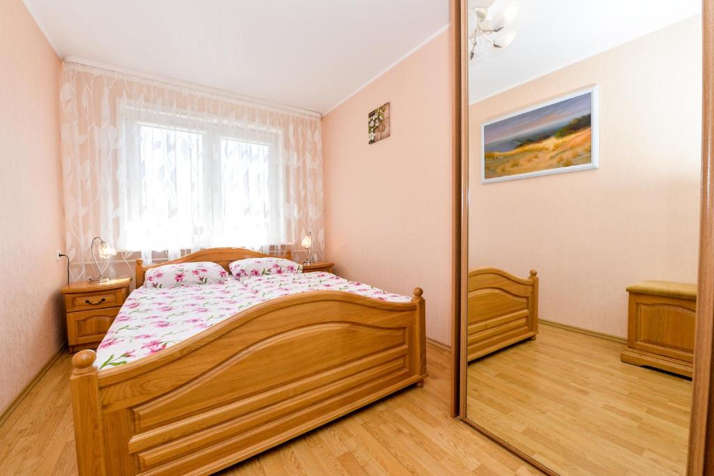 a bedroom with a bed and a mirror at Guesthouse "Nakvyne pas zveja" Nagliu street in Nida