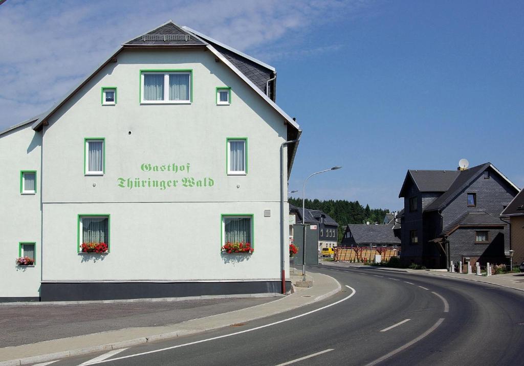 a white building on the side of a road at Pension Thüringer Wald in Reichmannsdorf