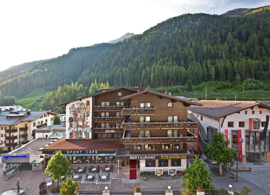 a hotel in a town with a mountain in the background at Sporthotel St. Anton in Sankt Anton am Arlberg