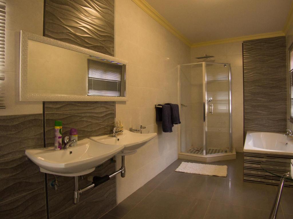 een badkamer met 2 wastafels en een douche bij Oleratong Guest House in Evander