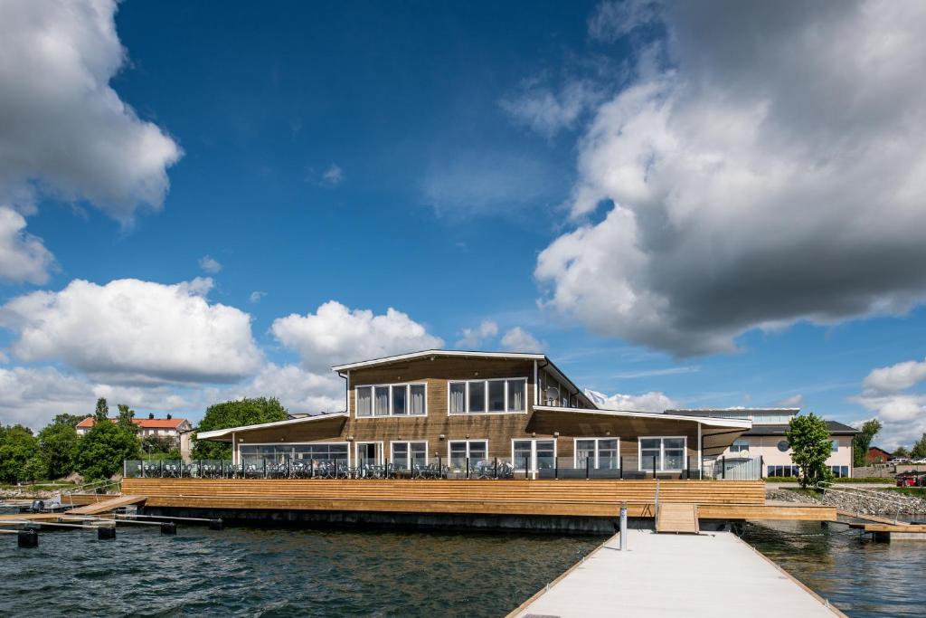 ein Haus auf einem Dock neben einem Wasserkörper in der Unterkunft Strandpiren Hotell in Hudiksvall