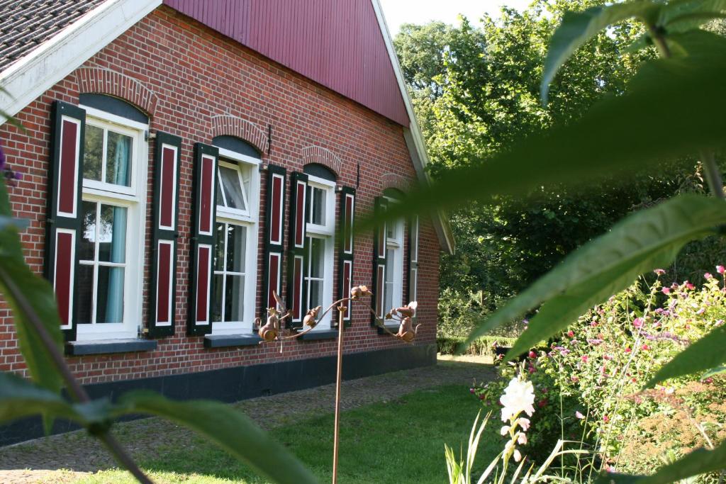 アールテンにあるHuusken op de Kampの白い窓のある赤レンガ造りの家