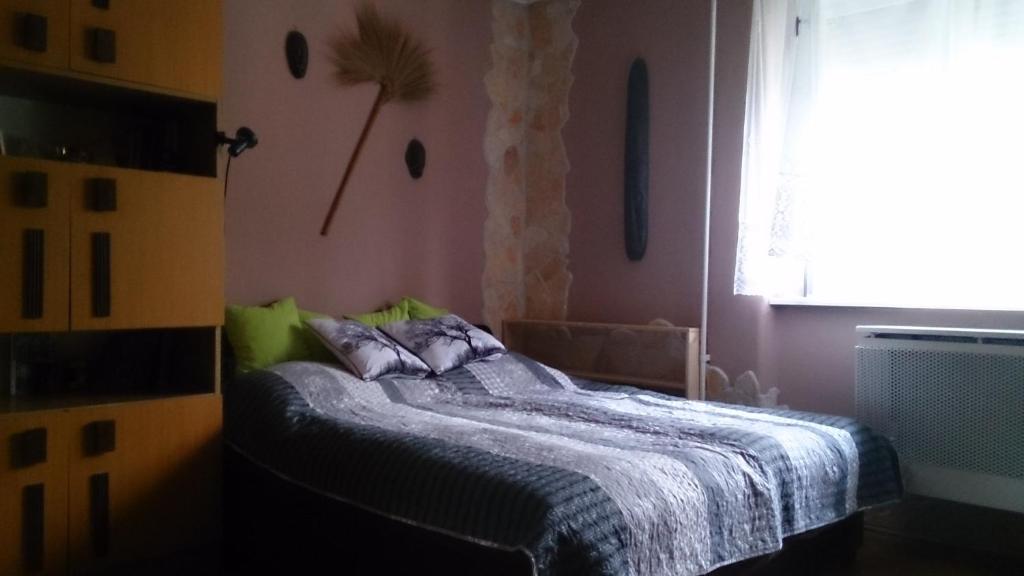 um quarto com uma cama e uma janela em Boris Apartman em Gyula