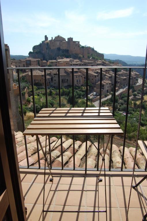 uma varanda com uma mesa e vista para a cidade em casa sampietro 2 em Alquézar