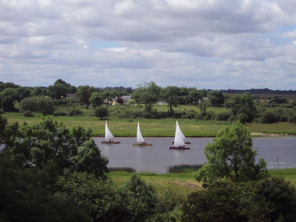 three boats with white sails on a lake at Shannonside Studios in Athlone