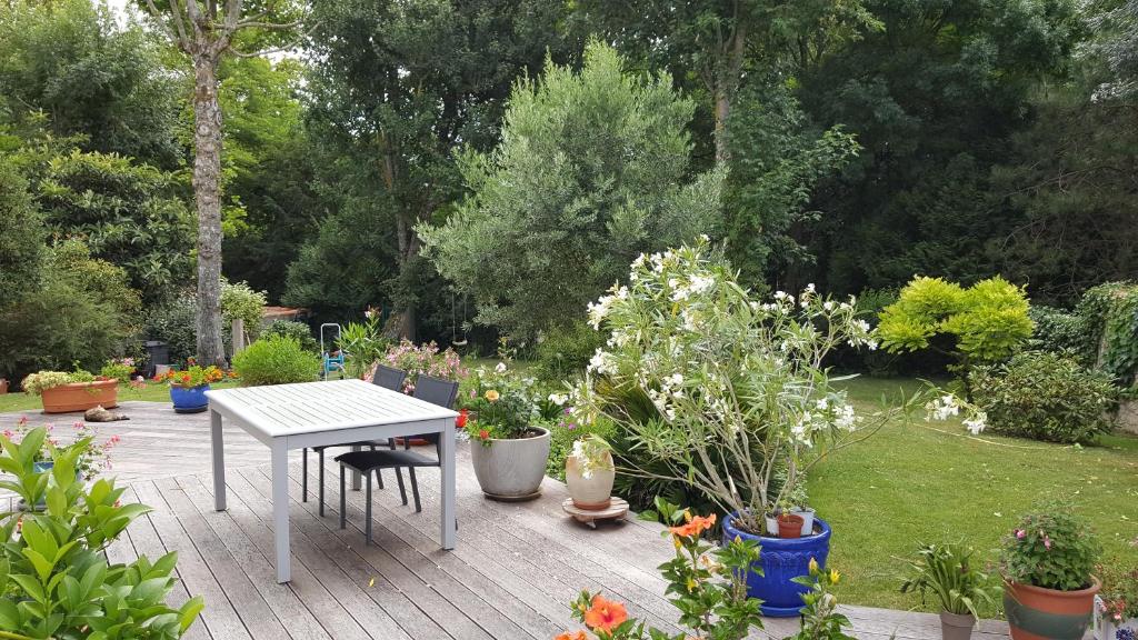 un patio con una mesa y un montón de macetas en Castel Parc, en Périgny