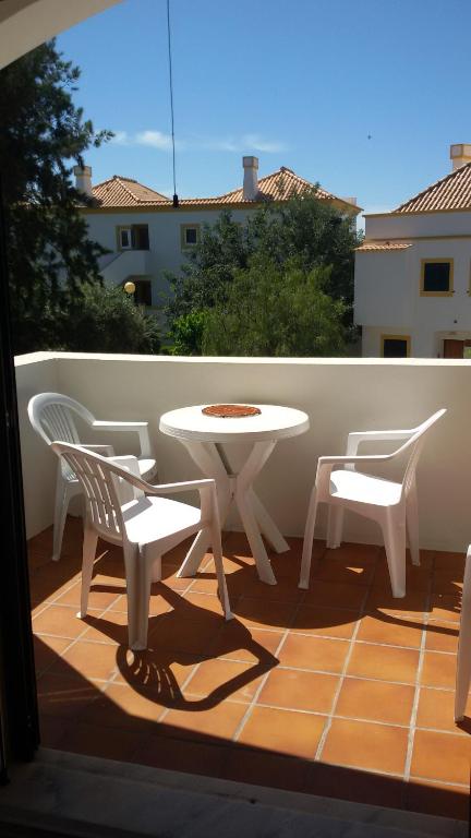 タヴィラにあるCharming Monte da Eira- one bedroomの白いテーブルとバルコニー(椅子2脚付)