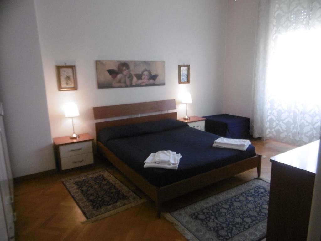 ローマにあるGG Bed and Breakfastのベッドルーム1室(ベッド1台、ナイトスタンド2台、ランプ2つ付)