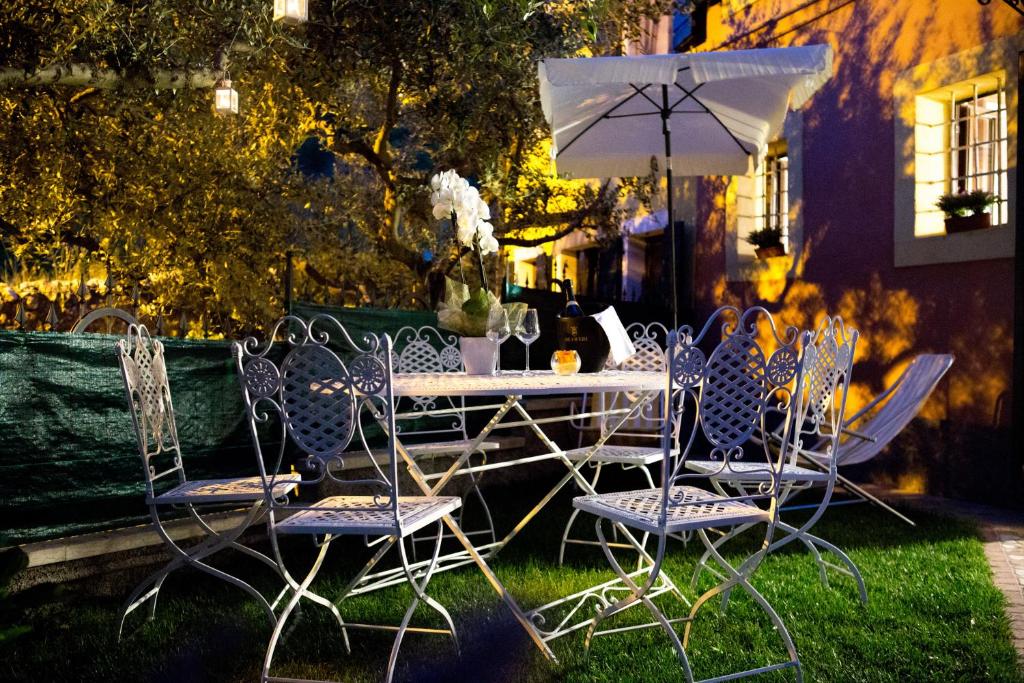 PoianoにあるCorte Alta Veronaの椅子と傘が置かれた芝生のテーブル
