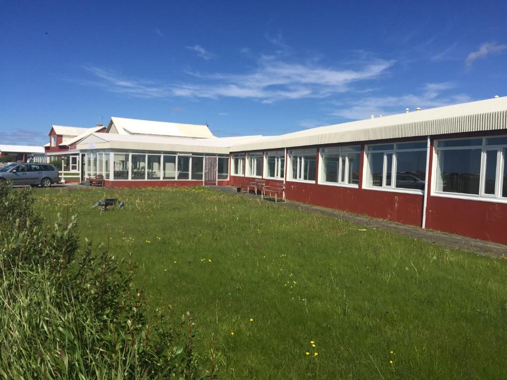 a building with a grass field in front of it at Ocean Beach Apartments in Stokkseyri