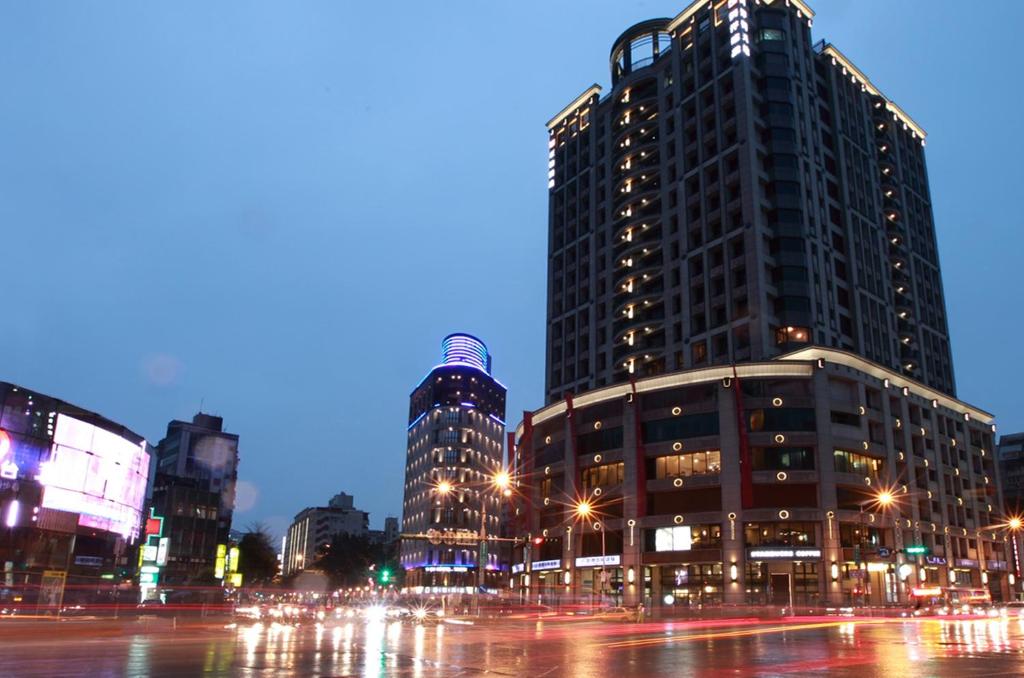 ulica miejska w nocy z wysokimi budynkami w obiekcie 晶城青年旅館 4f w Tajpej