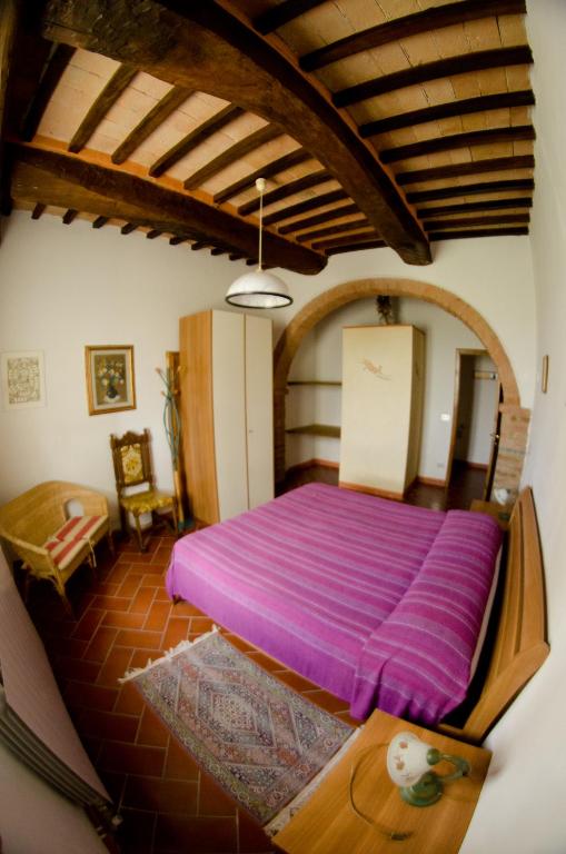 a bedroom with a large purple bed in a room at Podere Remignoli in San Gimignano