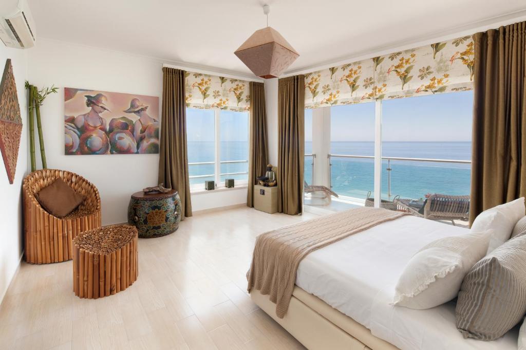a bedroom with a bed with a view of the ocean at CALI Deluxe Holidays, Sesimbra in Sesimbra