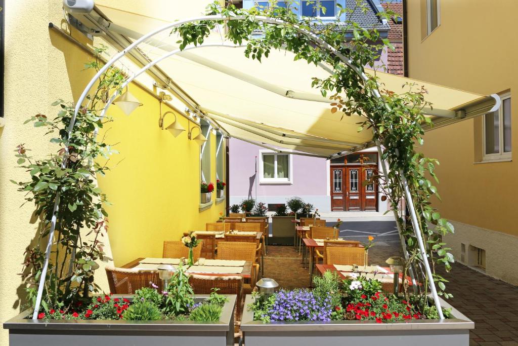 un patio al aire libre con un arco y flores en City Hotel, en Schopfheim