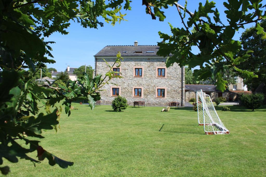 an old stone building with a soccer ball in a yard at Apartamentos Casa Cerolleiro in Castropol