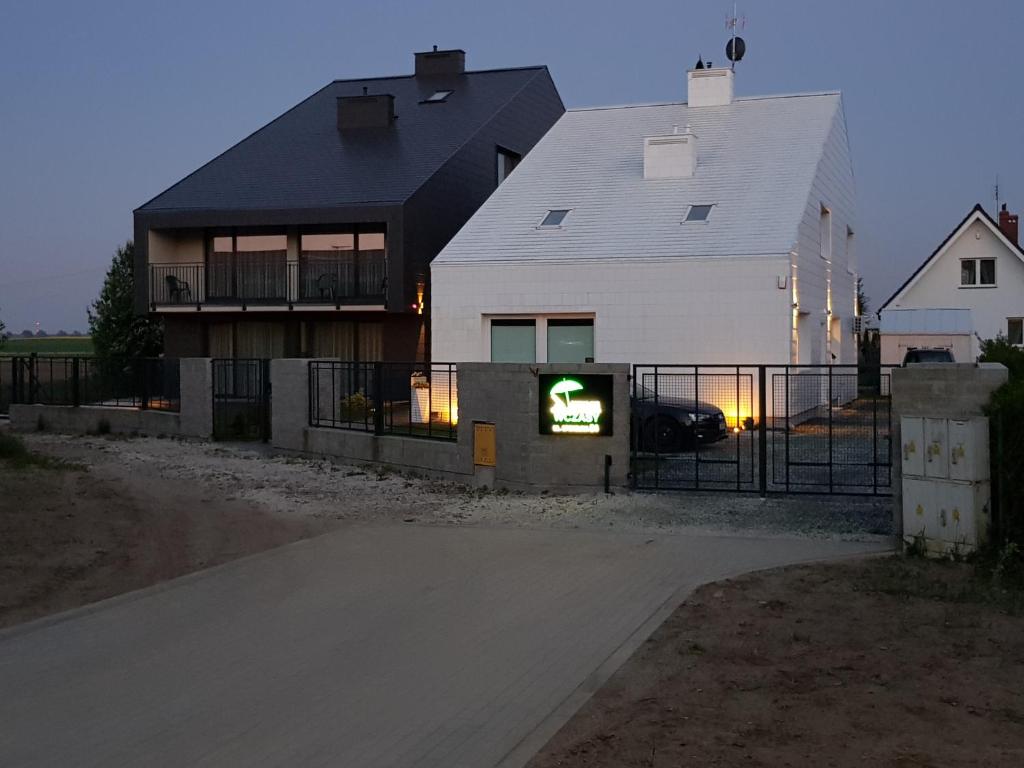 a house with a sign in front of it at Spokojne Wczasy in Mielno