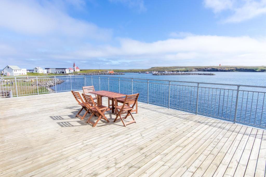 RaufarhöfnにあるHotel Nordurljosのテーブルと椅子が備わるデッキから水辺の景色を望めます。