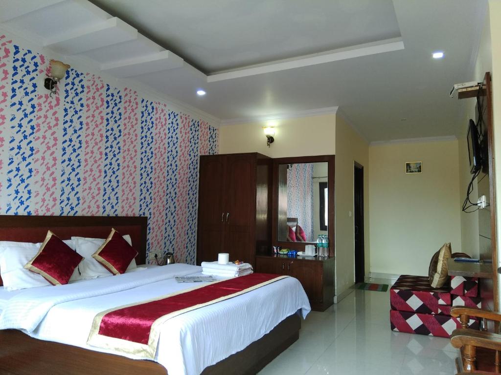 una camera da letto con un grande letto con una coperta rossa di Basant Watika a Mussoorie