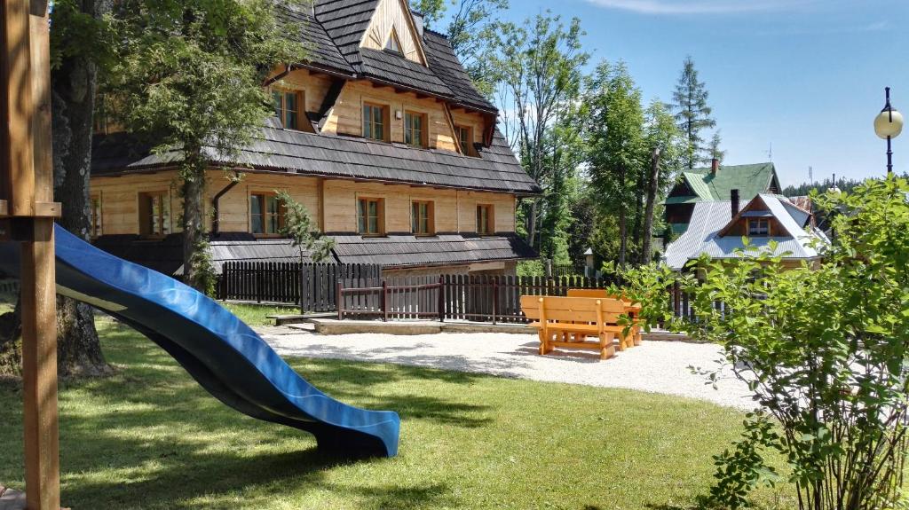 a playground with a slide in front of a house at Apartamenty nad potokiem in Zakopane