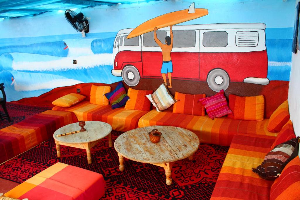 a room with a couch with a painting of a van at Sunny Apartments Taghazout in Taghazout