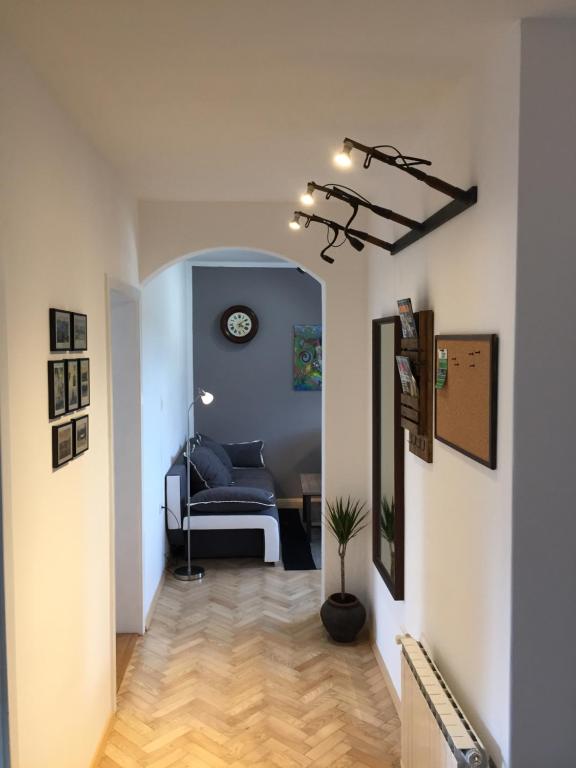 a hallway with a couch and a clock on the wall at Apartment Gondola in Maribor