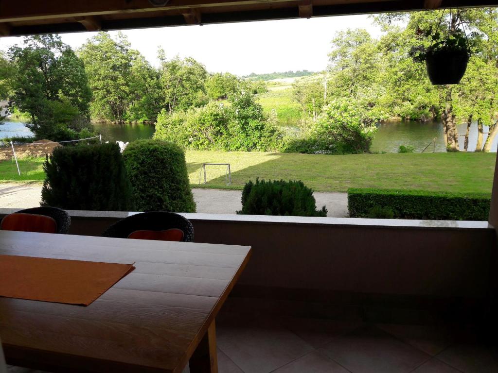 a room with a table and a view of a garden at Apartments Korana, BelajskePoljice in Duga Resa