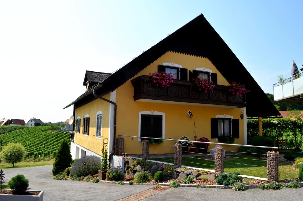 a yellow house with a black roof at Gästehaus Friedrich in Klöch