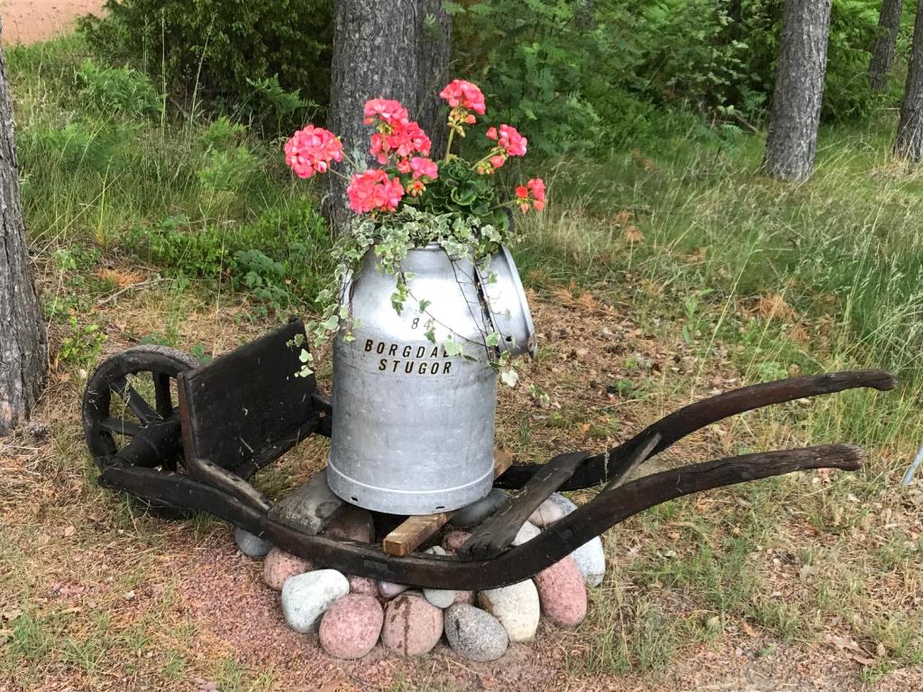 um arranjo de flores em uma lata com chifres em Borgdala Stugor em Ödkarby