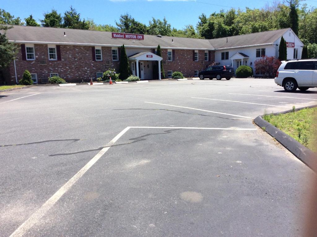 un aparcamiento vacío frente a un edificio de ladrillo en Wickford Motor Inn, en North Kingstown