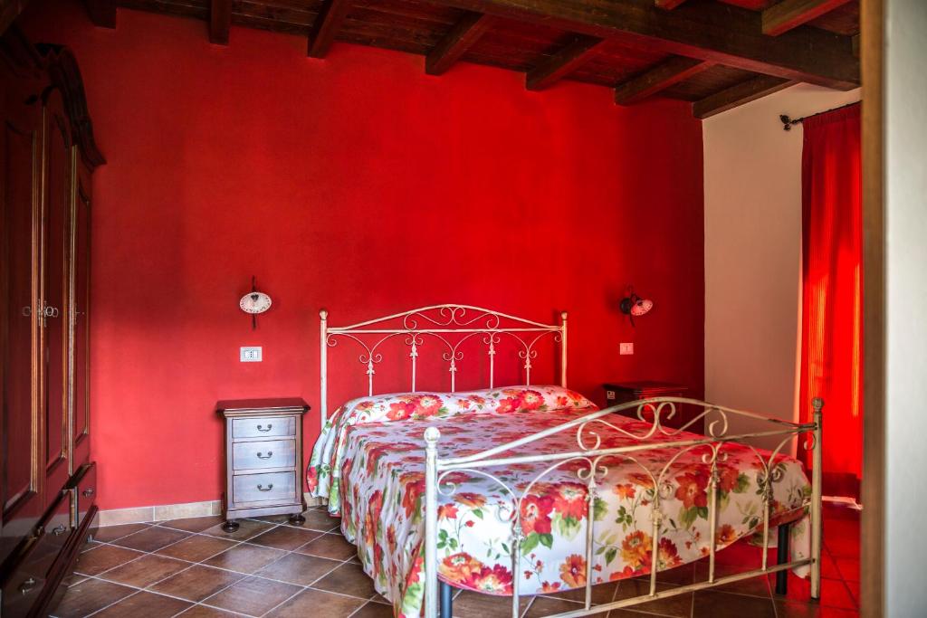TorrettaにあるAgriturismo Aureaの赤い壁のベッドルーム(ベッド1台付)