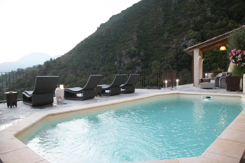 a swimming pool with lounge chairs and a mountain at Casa Di Lucia Mi-Hotel in Mazzola