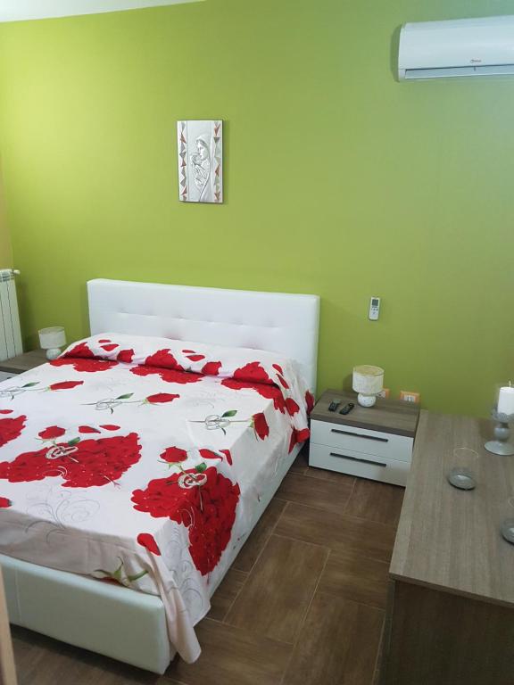a bedroom with a bed with red flowers on it at Appartamento Marinella in Pizzo