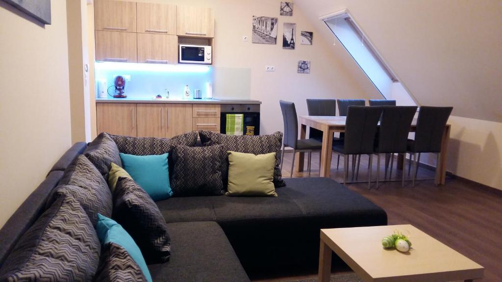 een woonkamer met een bank en een tafel bij Tahiti apartman in Hajdúszoboszló