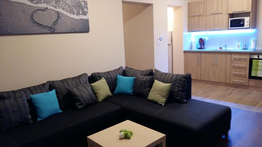 salon z czarną kanapą i niebieskimi poduszkami w obiekcie Tahiti apartman w Hajduszoboszlo
