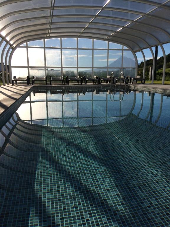 einen Pool in einem Gebäude mit einem großen Fenster in der Unterkunft Vale dos Cocos in Horta