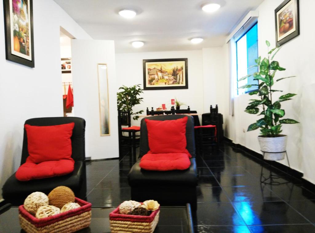 a waiting room with two chairs with red pillows at White Hope Apartment in Lima