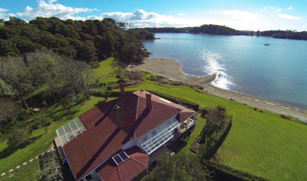 una vista aérea de una casa junto a un cuerpo de agua en Oakura Bay Villa, en Te Whau Bay