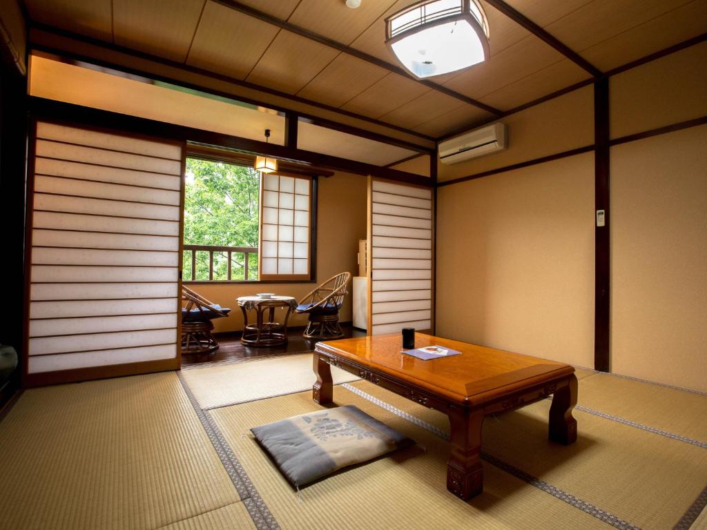 a living room with a table and a table sidx sidx sidx at Oogi Onsen Oogiso in Minamioguni