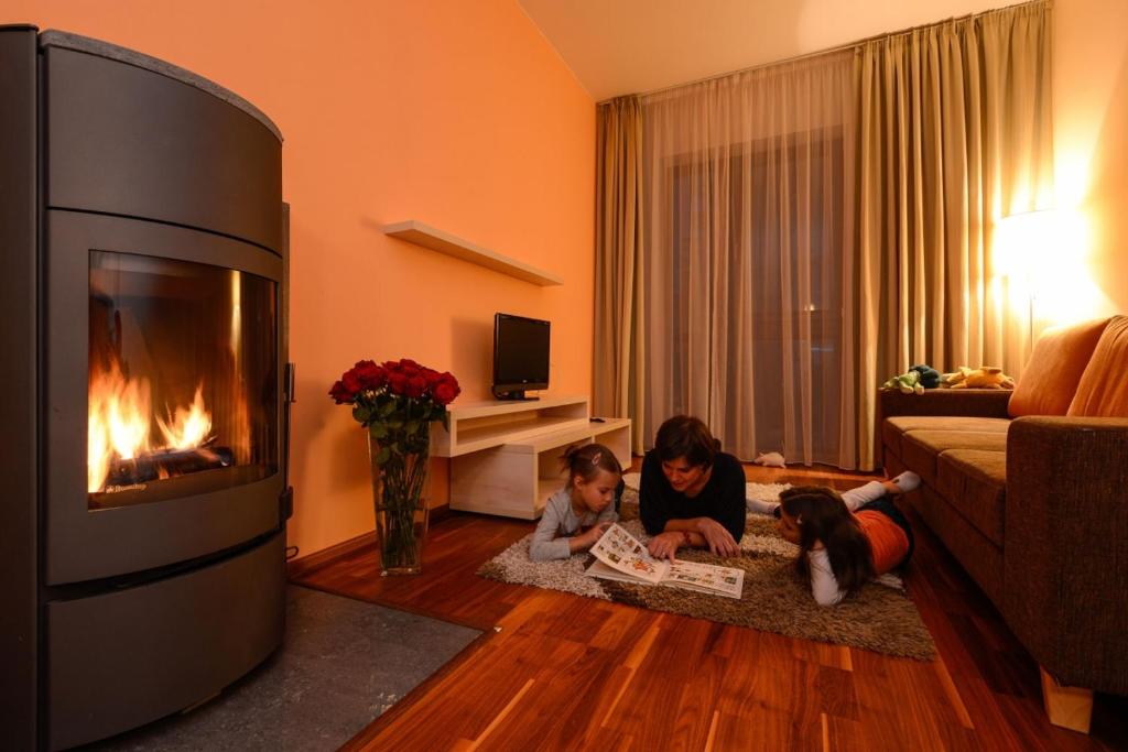 two children laying on the floor in a living room with a fireplace at Crocus Apartments 310, 507 in Štrbské Pleso