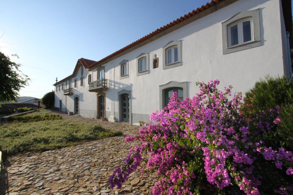 um edifício com flores roxas em frente em Casal De Tralhariz - Turismo De Habitacao em Tralhariz