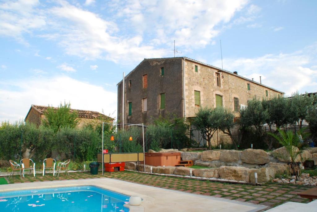 a building with a swimming pool in front of a building at Turó de la Torre in Manresa