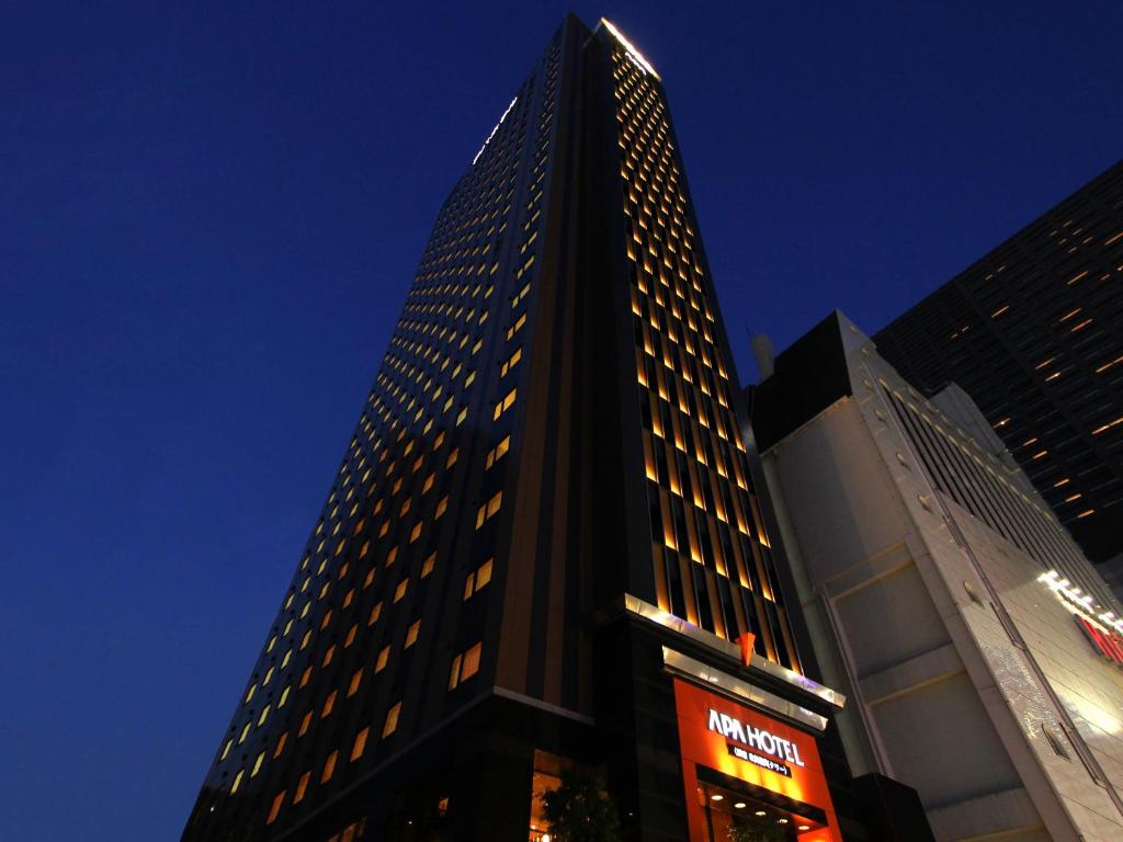 ein hohes Gebäude mit einem Schild davor in der Unterkunft APA Hotel Shinjuku-Kabukicho Tower in Tokio