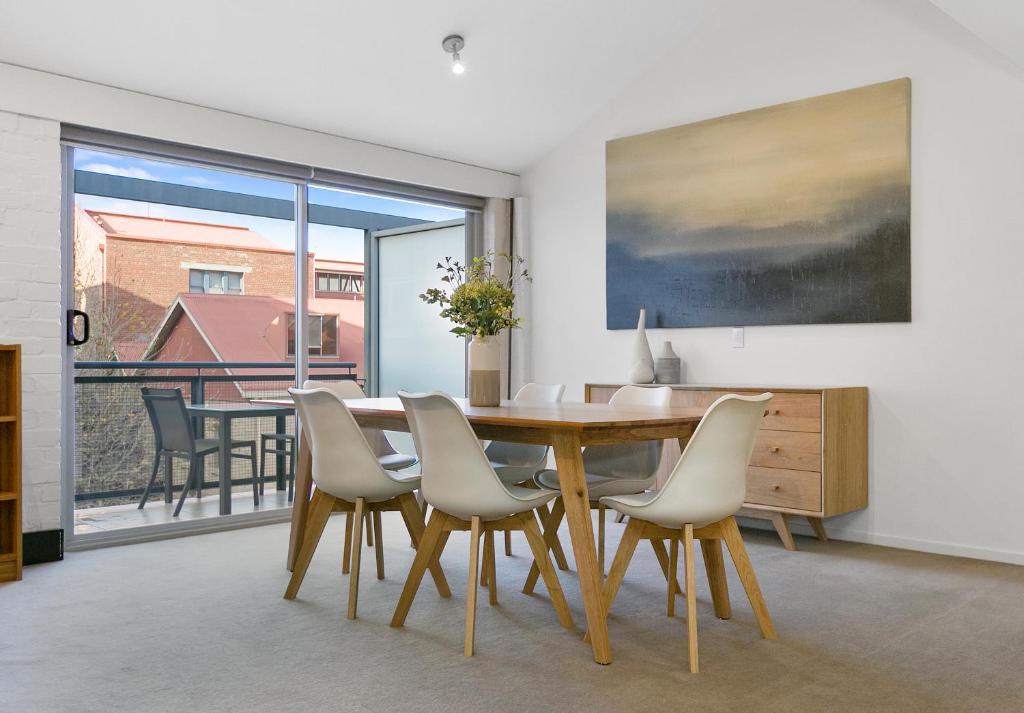 een eetkamer met een houten tafel en stoelen bij Sullivans Cove Apartments in Hobart