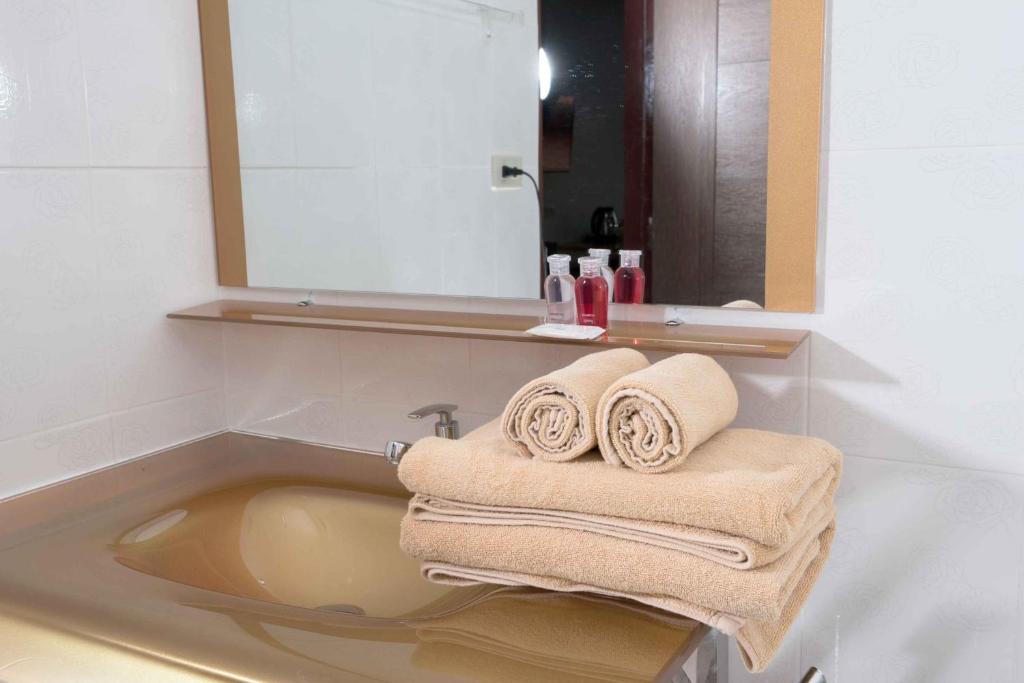 a bathroom with a sink with towels in it at VC Hotel Phayao in Phayao