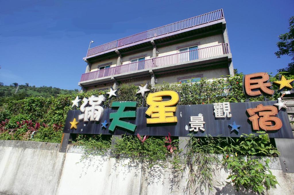 un edificio con una señal delante de él en Stars B&B, en Suao