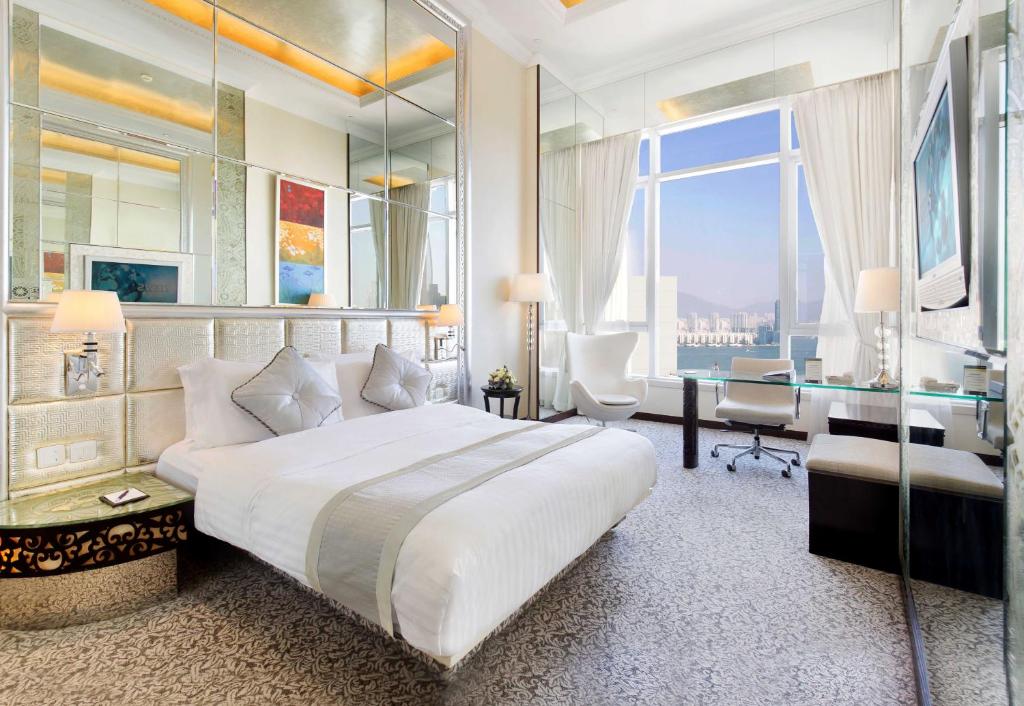 a bedroom with a large white bed and a desk at Regal Hongkong Hotel in Hong Kong