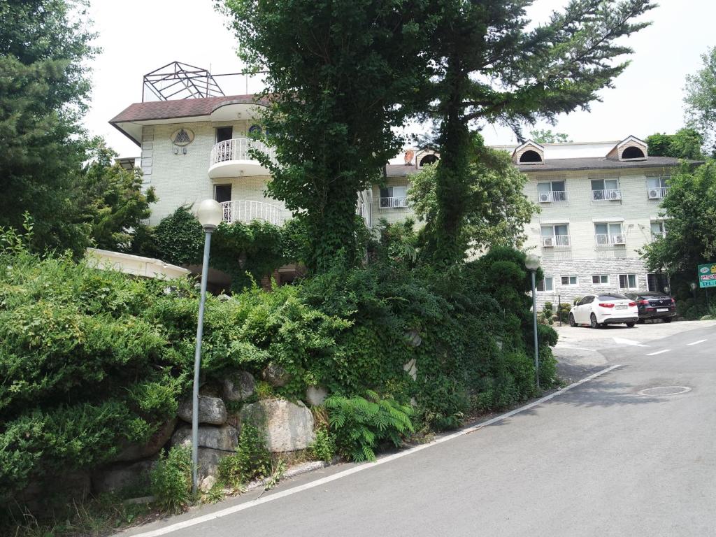 a building with a tree on the side of a street at Sorak Garden Resortel in Sokcho