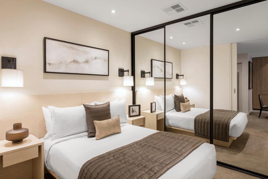 Postel nebo postele na pokoji v ubytování SKYE Hotel Suites Parramatta
