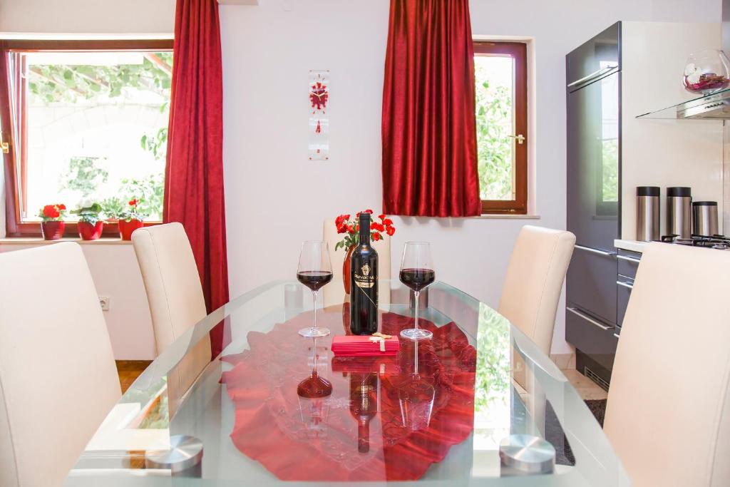 a glass dining room table with wine glasses on it at Holiday Home Mirela in Orebić